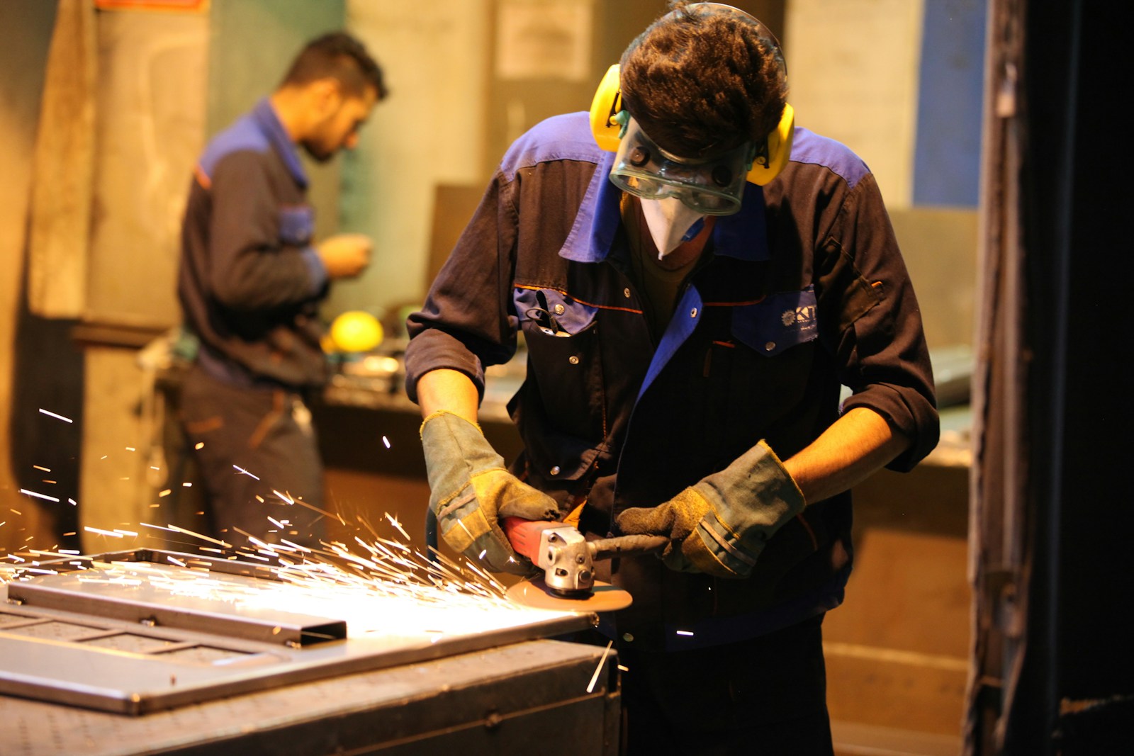man in black long sleeve shirt holding gray metal tool, workers